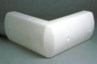White L-shaped foam corner protector with rounded edges on a gray background