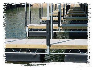 Floating dock walkway over water with repeating wooden platforms and metal railings