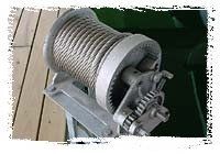 Large gray industrial cable drum with coiled wire on a metal frame in a workshop