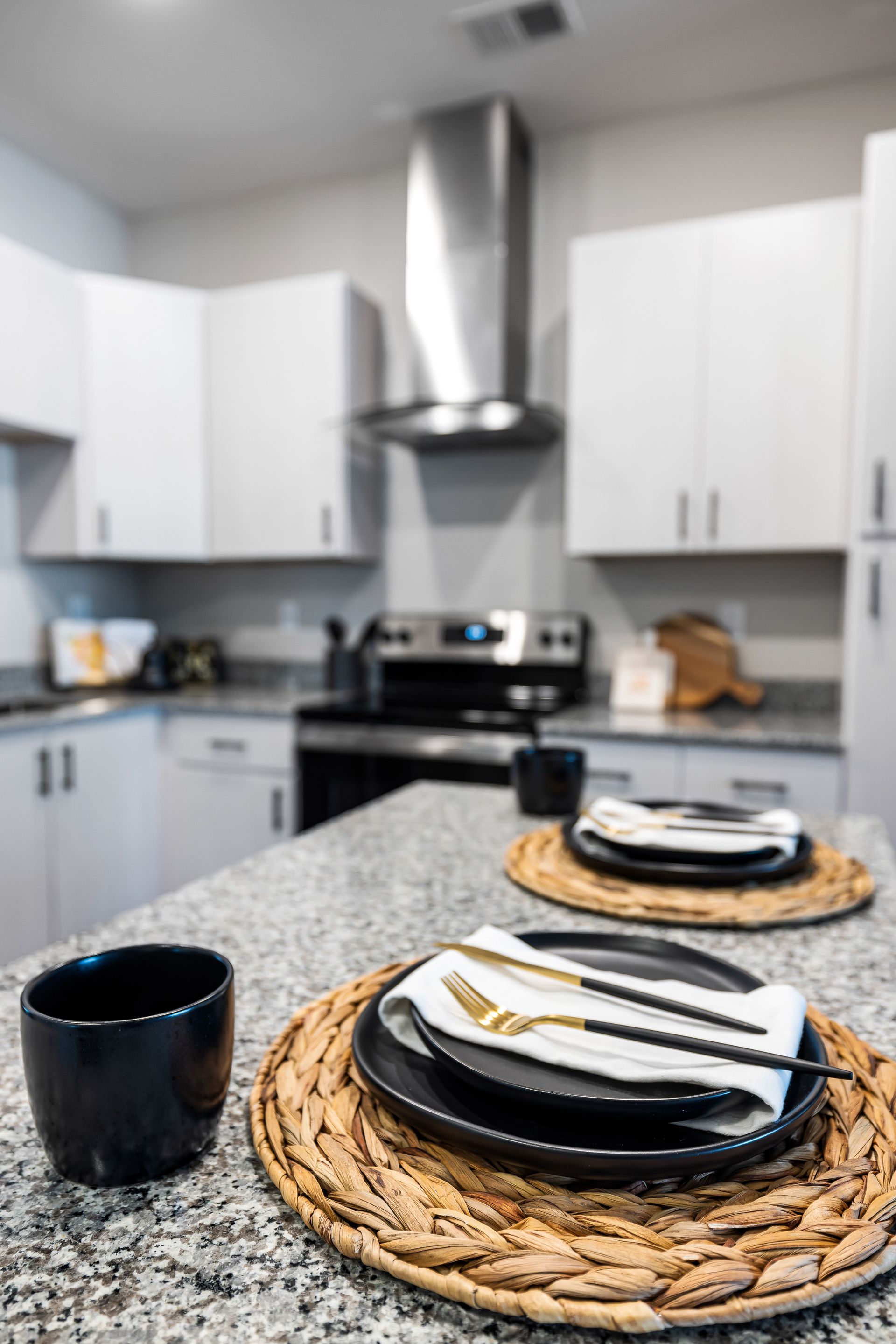 Set breakfast plates and cups on a woven placemat in a bright modern kitchen