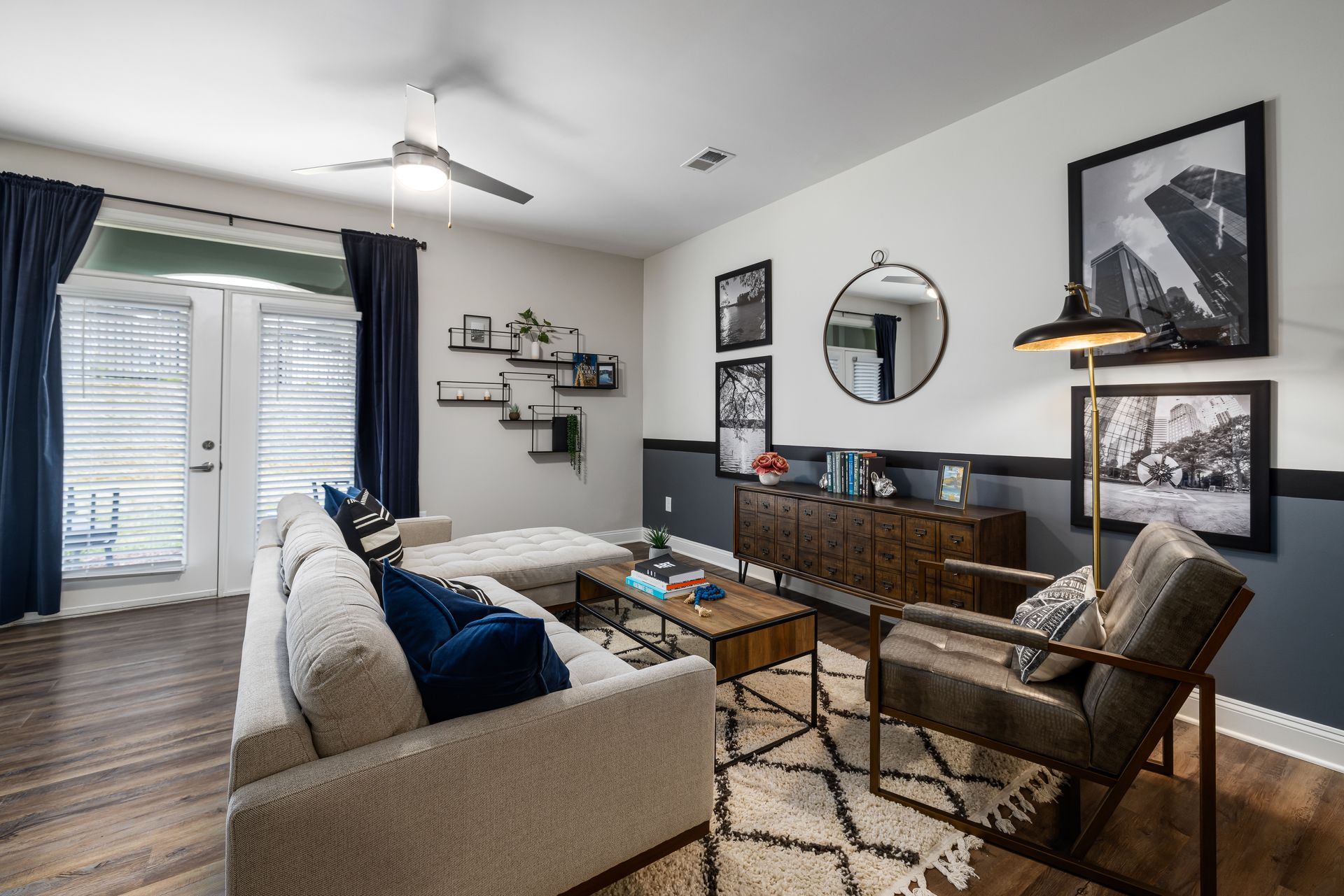 Bright living room with beige sofa, wood sideboard, patterned rug, wall art, and sliding glass doors to a balcony