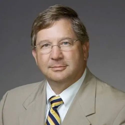 A man in a suit and tie is wearing glasses.
