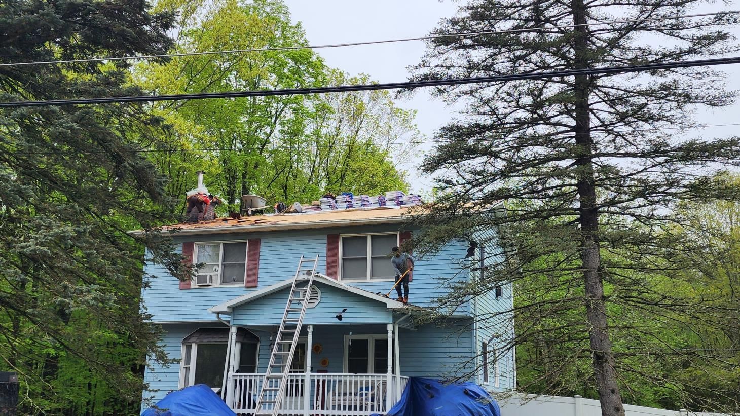 Skilled professional repairing metal tiles on a roof with precision and expertise.