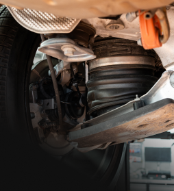 Close-up of a vehicle’s undercarriage showing suspension, wheel, and brake components | E&R Automotive