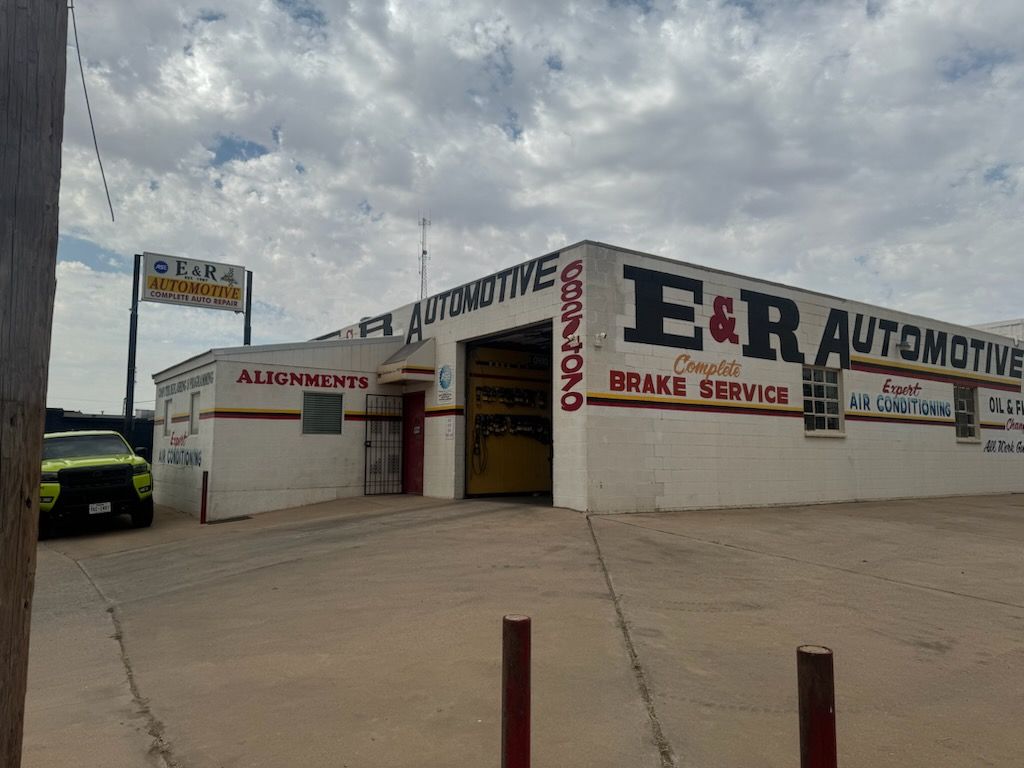 E&R Automotive shop exterior with orange brake service sign under a cloudy sky | E&R Automotive