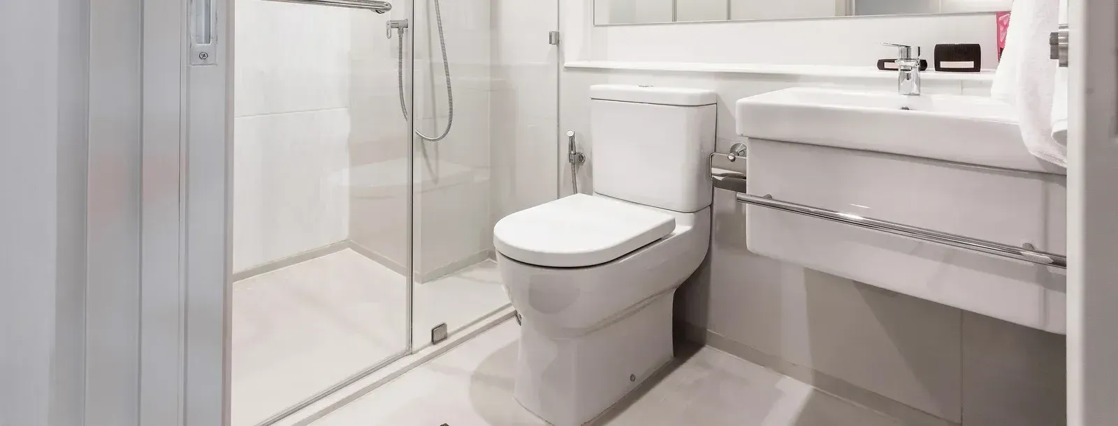 A bathroom with a toilet , sink and shower.