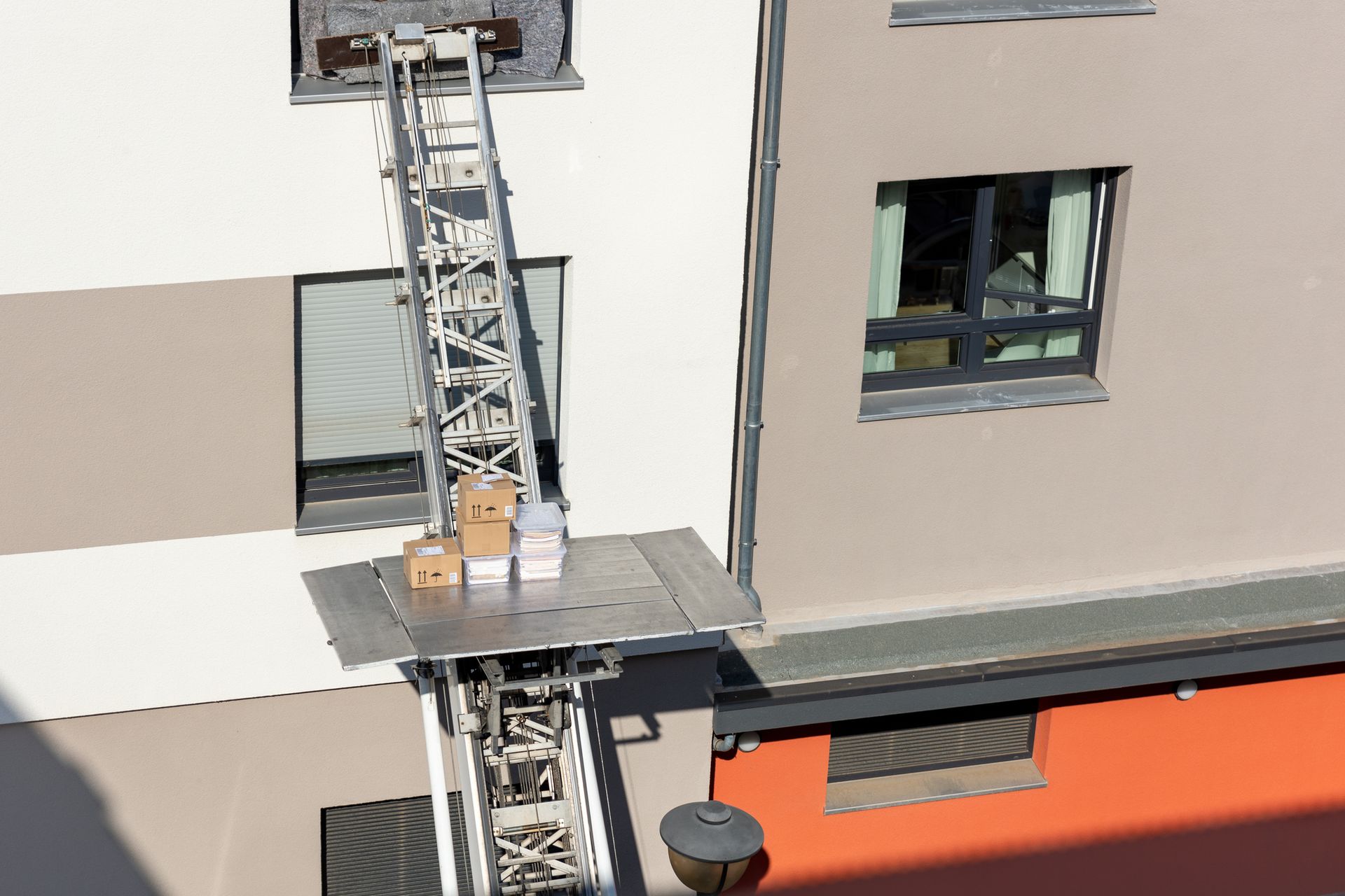 Trasloco di scatole su una piattaforma elevatrice estesa fino alla finestra di un edificio.