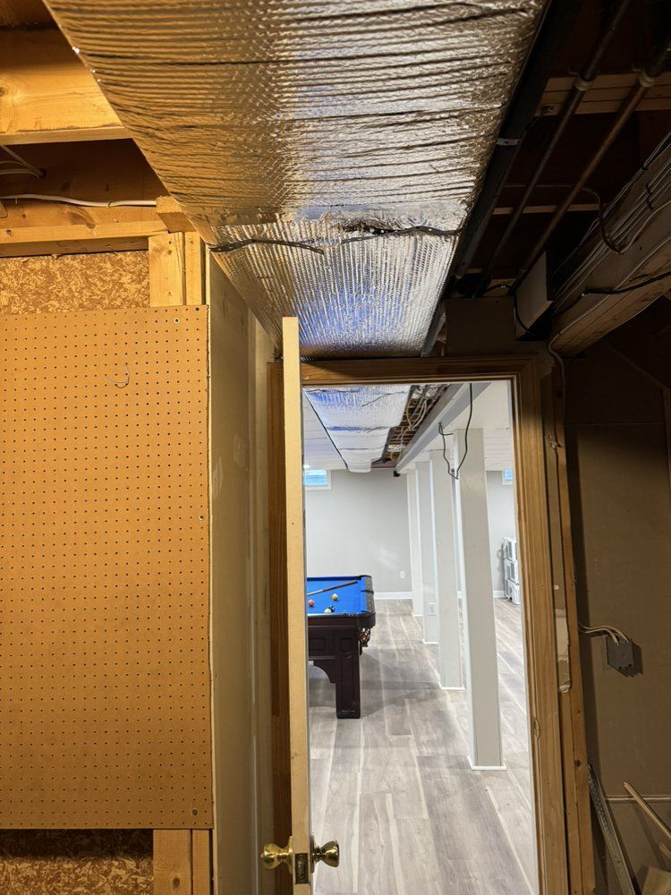 View of a basement doorway. A pool table is visible in the room, grey flooring, and white support beams.