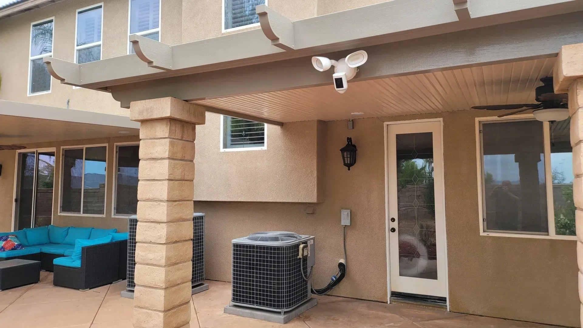 The backyard of a house with a pergola and a couch.
