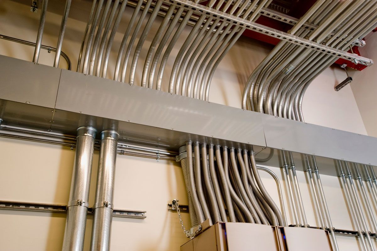 A bunch of metal pipes are hanging from the ceiling
