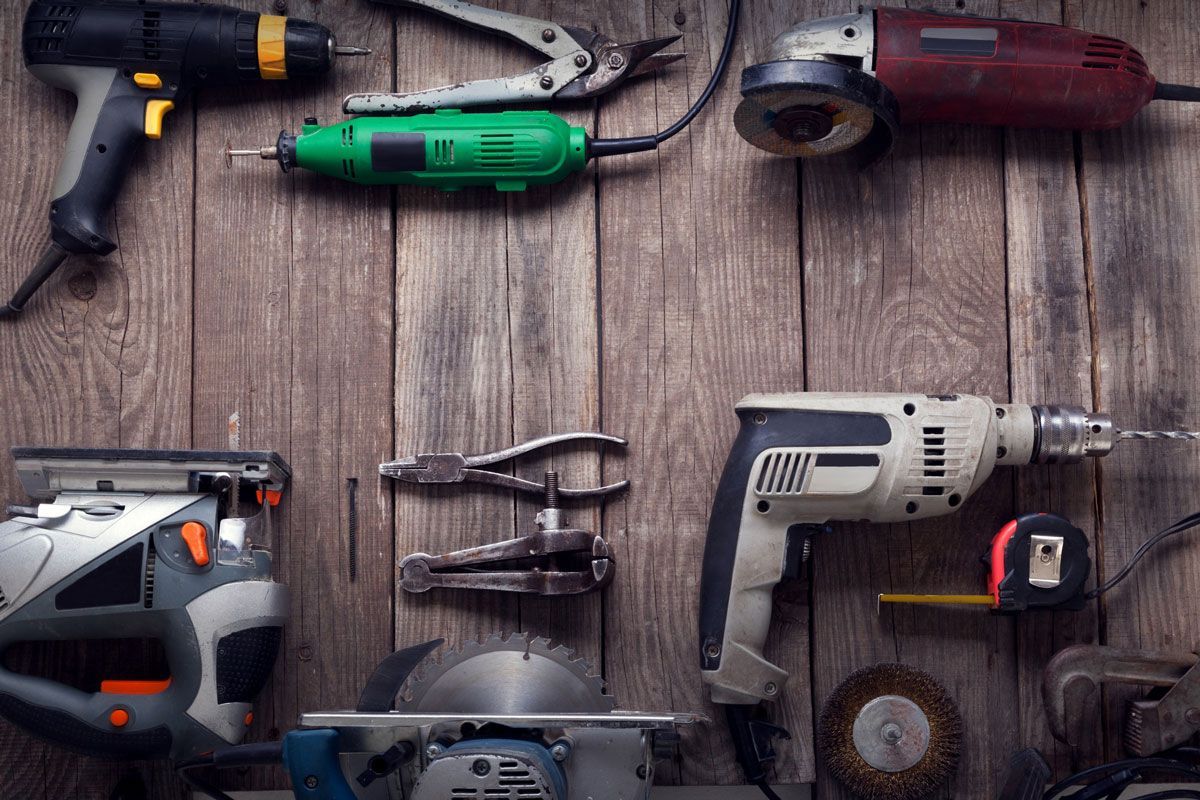 A bunch of tools are sitting on a wooden table.