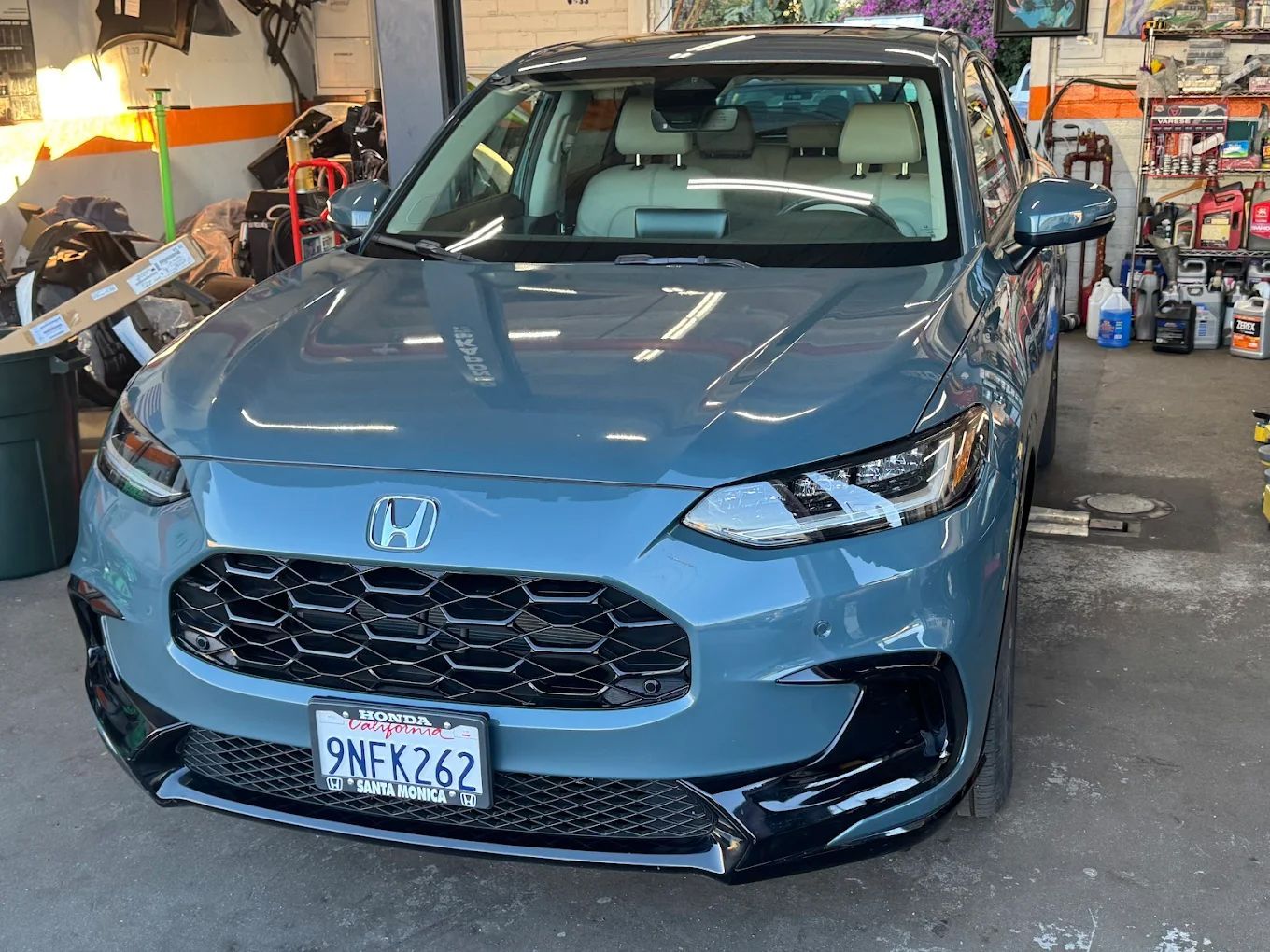 Blue Honda SUV parked in a garage, front view