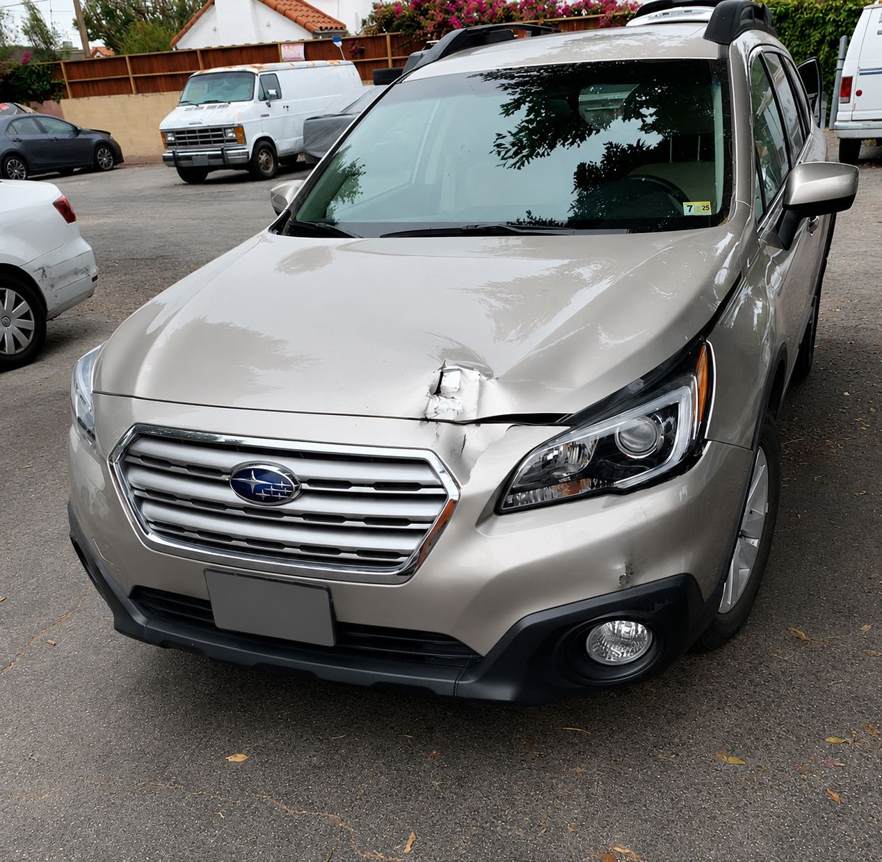 Silver Subaru SUV parked in a lot, front view with headlights and grille visible