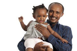 man holds up young child