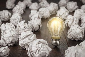 lightbulb surrounded by crumpled up paper
