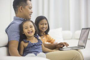 A man is working with two daughters around