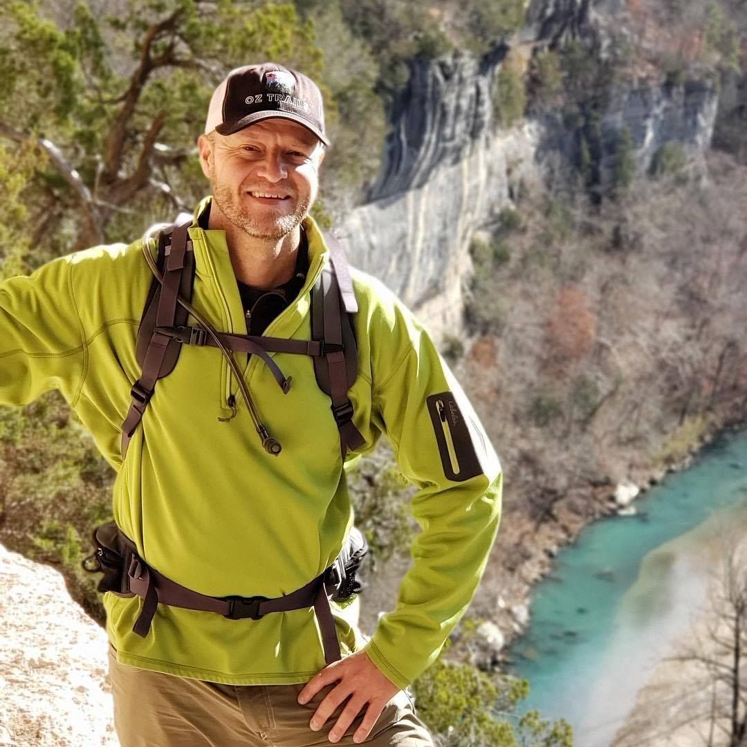 Photo of Erin Rushing overlooking a tall bluff and river below