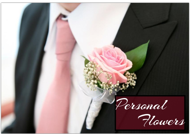 Pink rose boutonniere with baby's breath on a black suit and pink tie, labeled
