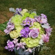 Bouquet of purple, lavender, and lime-green flowers against a grassy background