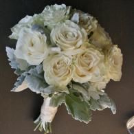 Bouquet of white roses with pale green leaves on a dark background