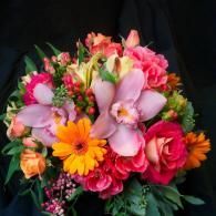 Colorful bouquet of pink, purple, orange, and red flowers on a dark background