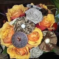 Yellow and orange roses arranged with vintage metal buttons and brooches