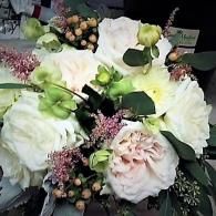 White and pale pink roses with green buds and foliage in a floral bouquet