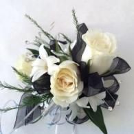 White and cream rose bouquet with dark green leaves and black ribbon accents