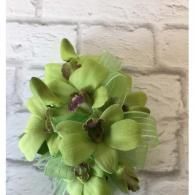 Green flower bouquet against a white brick wall
