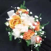 Orange and white rose bouquet with green accents on a black background