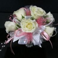 White rose bouquet with pink accents and ribbon on a black background