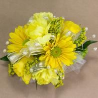 Yellow floral bouquet with daisies, white ribbon, and green accents on a beige background