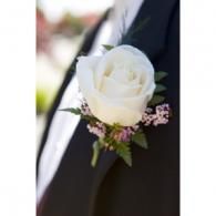 White rose boutonniere on a dark suit lapel