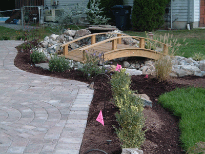 A small wooden bridge over a stream in a garden