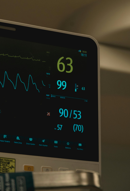 Hospital monitor showing vital signs: heart rate 63, oxygen 99%, and blood pressure 90/53.