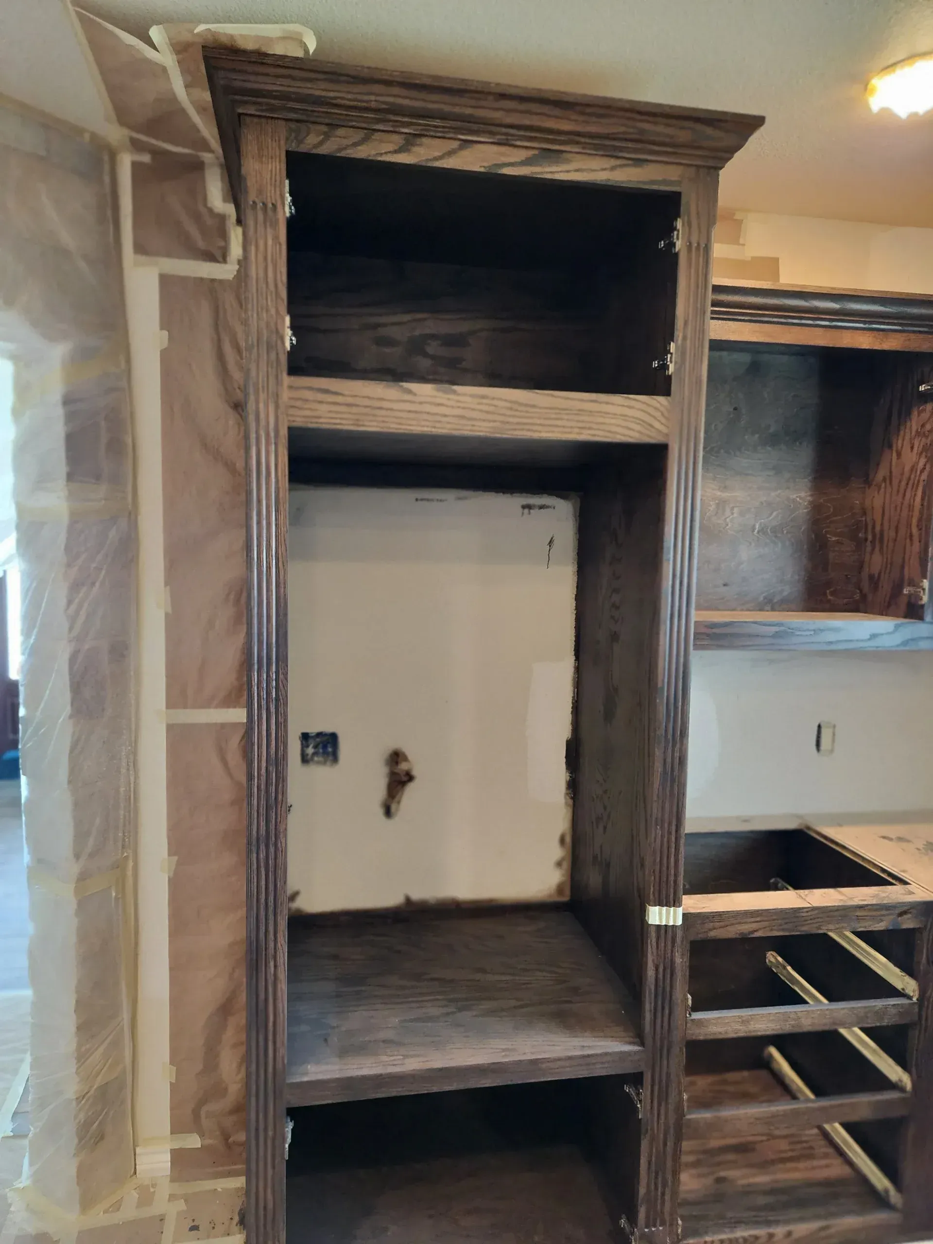Wooden cabinet with open shelves and a built-in appearance, in a kitchen setting.