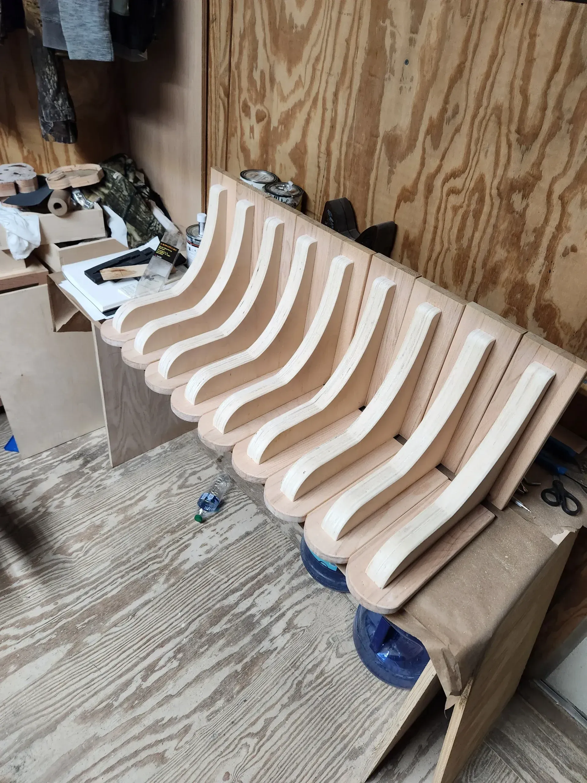 Wooden hockey sticks laid out on a wooden base. The sticks are light-colored and curved.