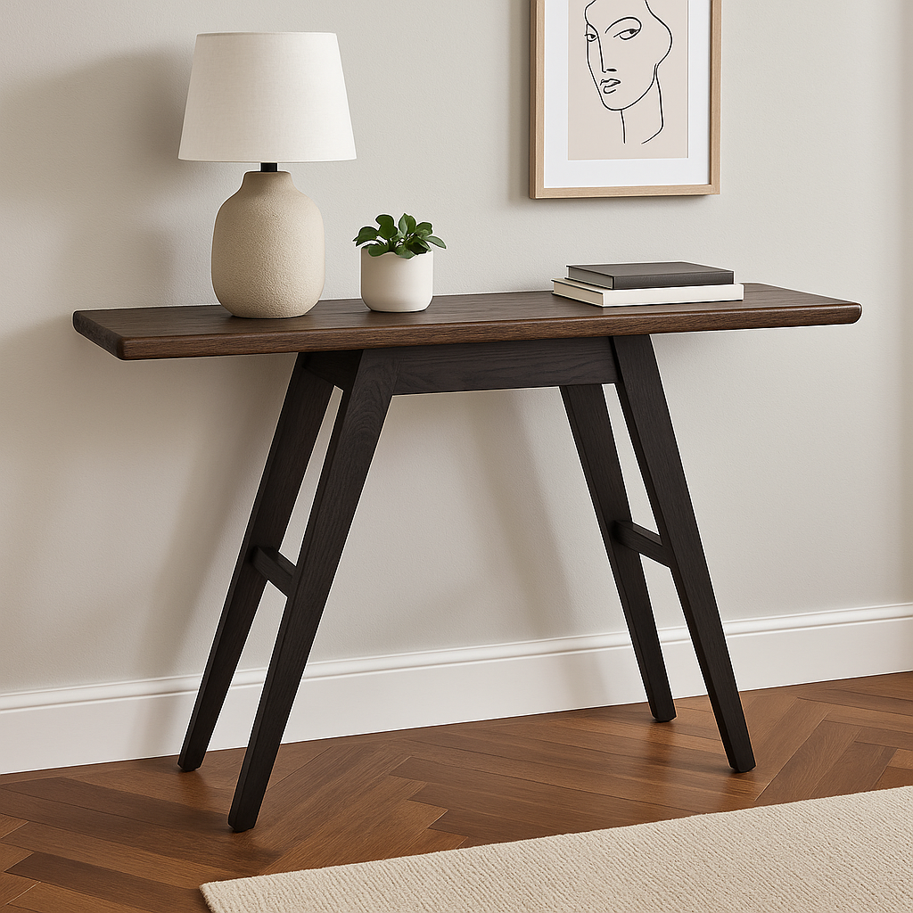 Dark wood console table with lamp, plant, and books against a wall with art.