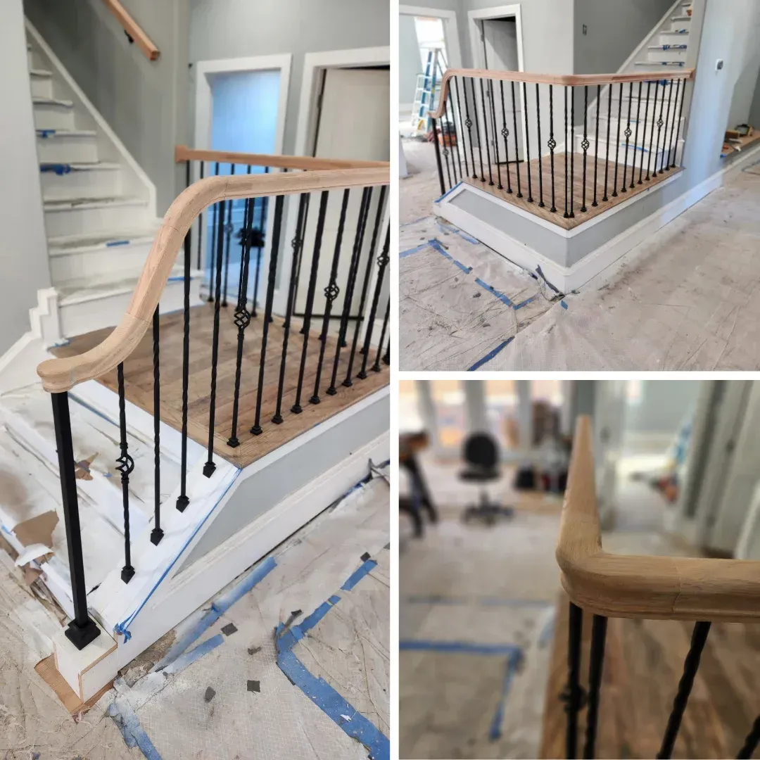 Staircase under construction with light wood handrail, black spindles, and blue tape on the floor.