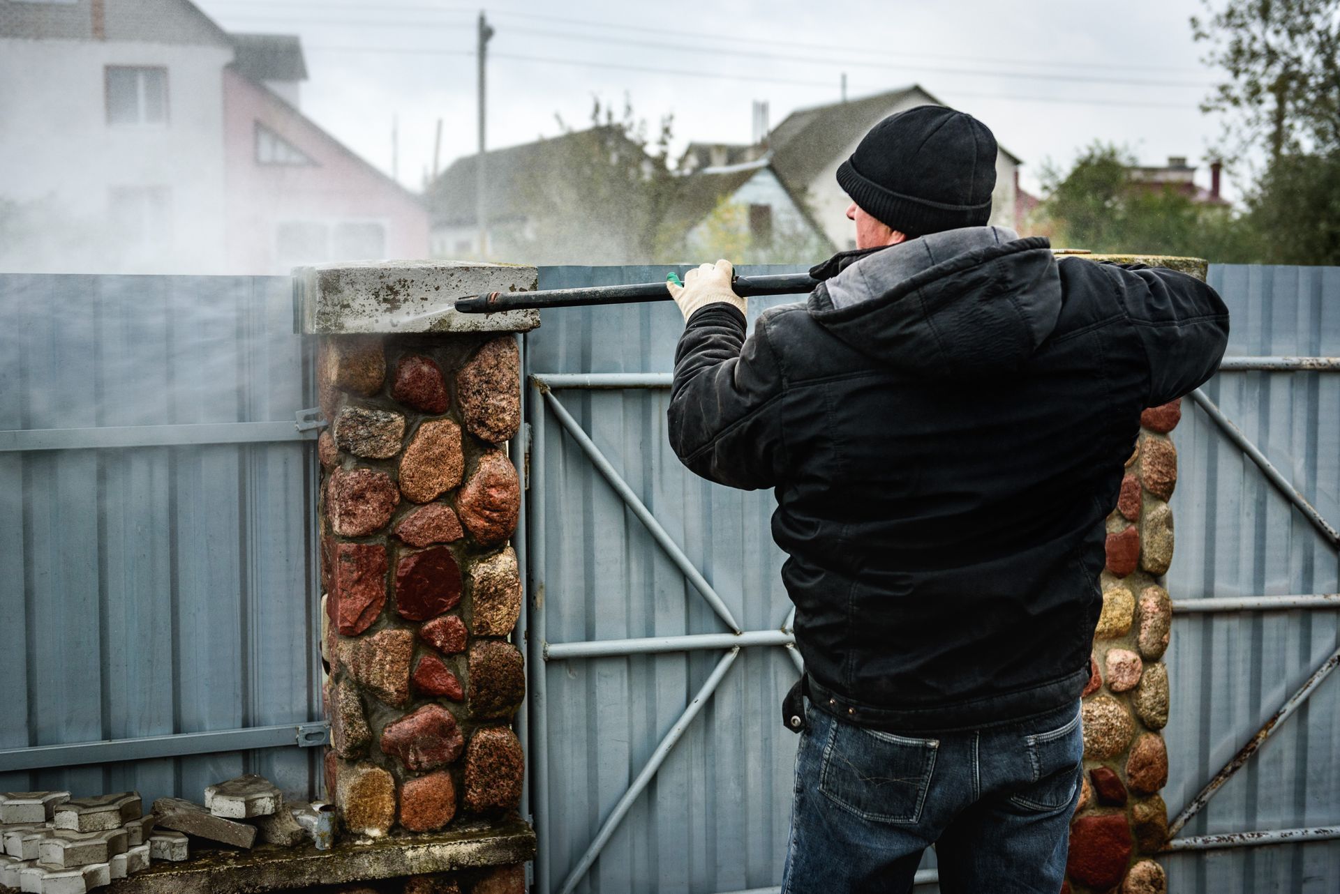 Person welding a metal gate in a smoky outdoor yard