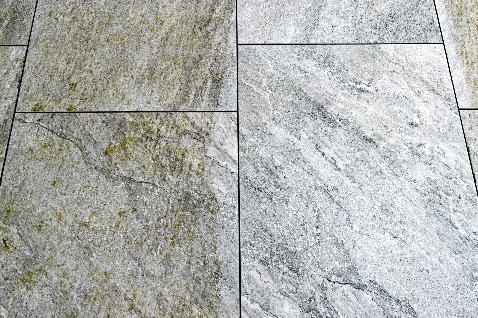 Close-up of gray and green stone tiles with visible seams and textured surface