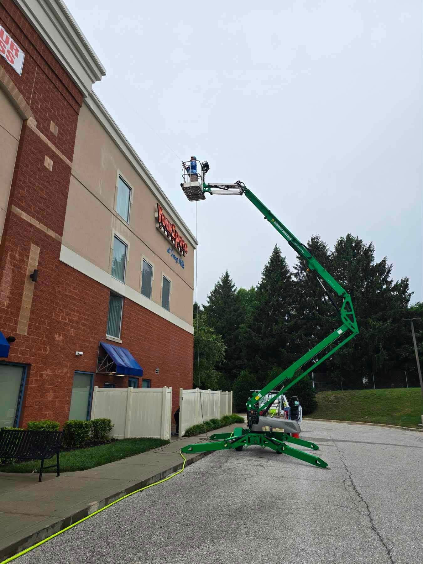 Two window washers on a suspended platform cleaning a high-rise building facade