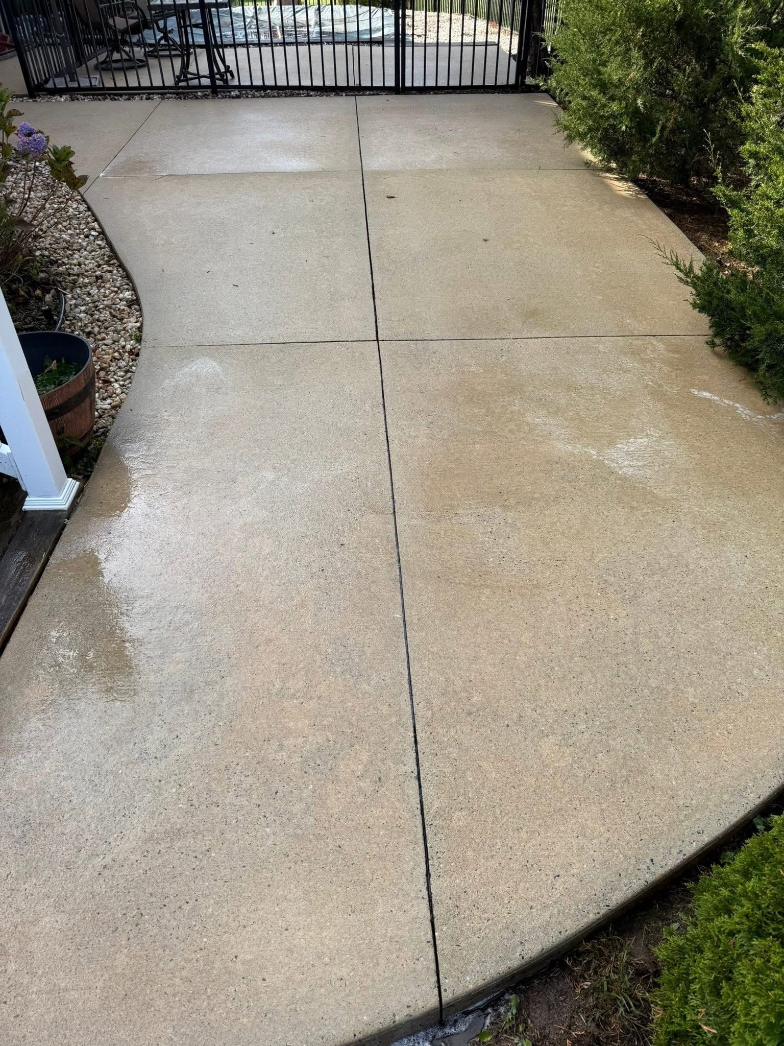 Pressure washing a weathered wooden deck with a spraying nozzle