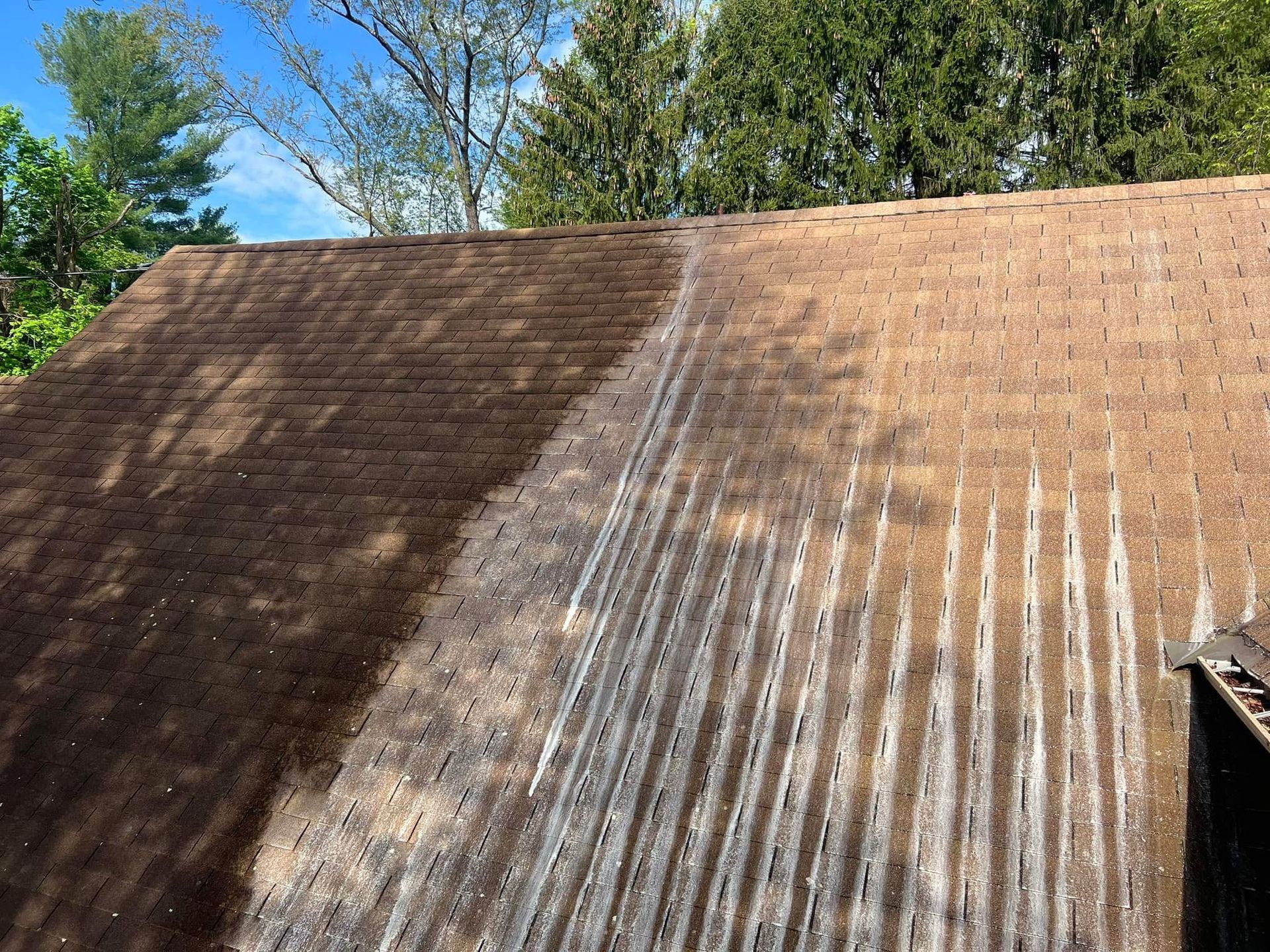 Pressure washing a wooden deck, spraying water across the surface