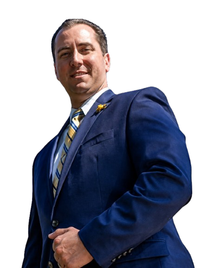 Man in a blue suit with a striped tie standing against a white background