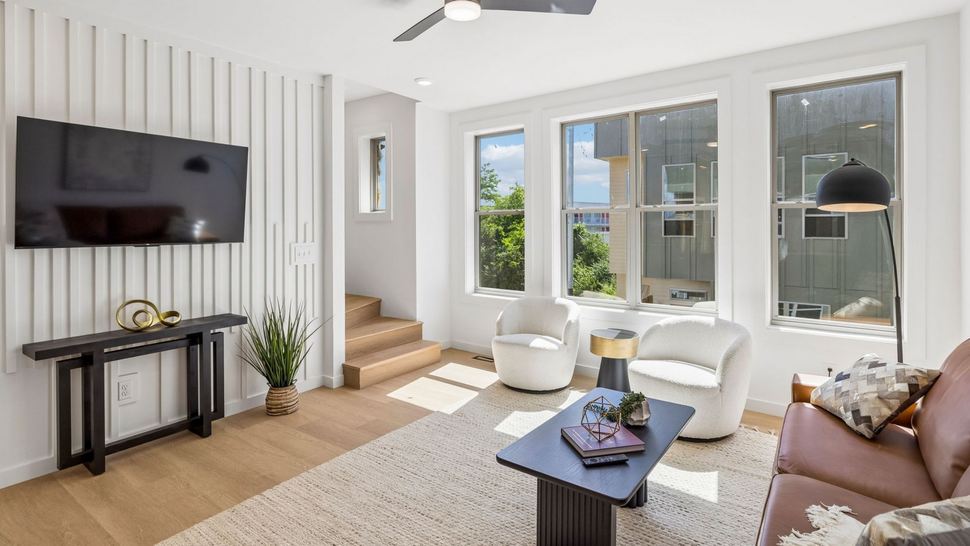 Photo of a living room with three separate windows, allowing for plenty of natural light