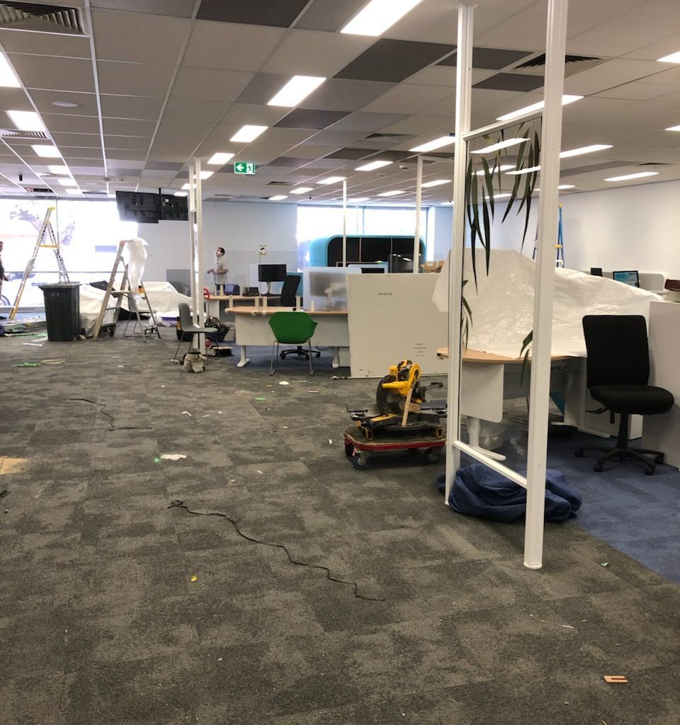 Open-plan office full of tools and construction mess before cleaning