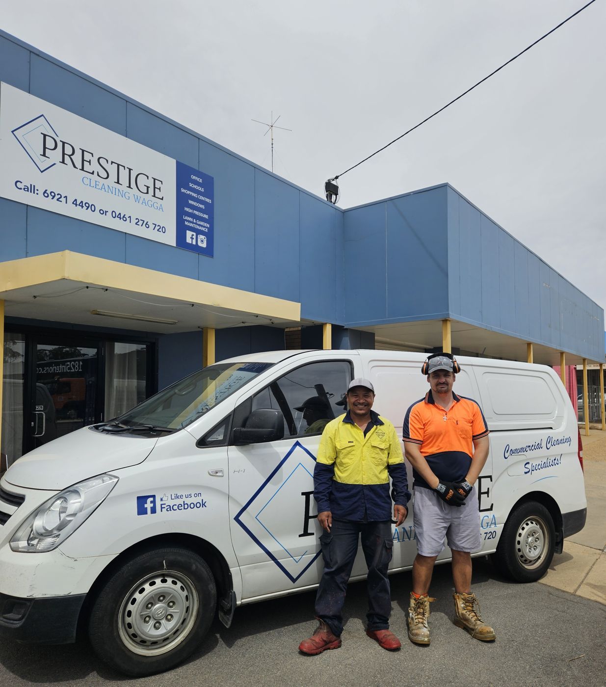 Two Prestige Cleaning Wagga staff in hi-vis beside the company van outside the Edward Street office