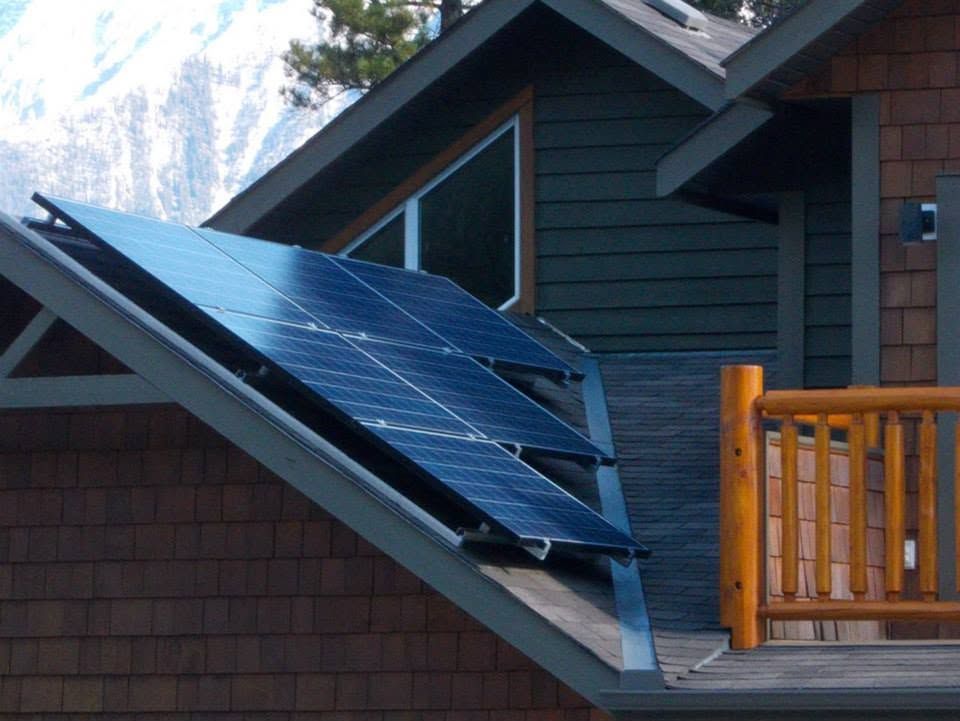 Solar panels mounted on a sloped roof beside a wooden balcony.