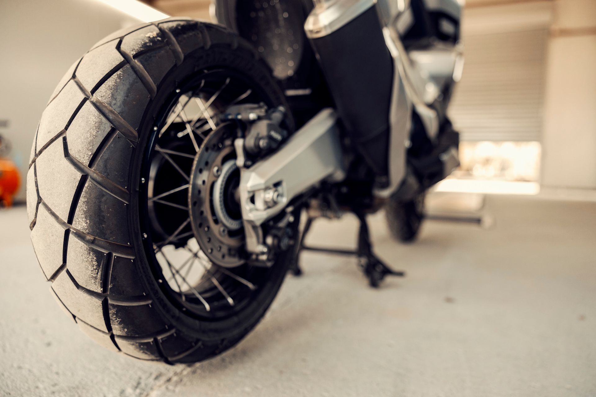 Un primer plano de la rueda de una motocicleta en un garaje.